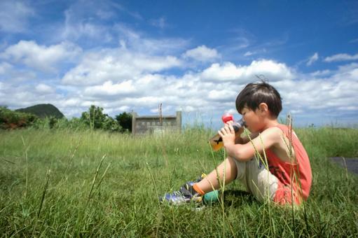 <Material> A boy drinking tea from a water bottle while playing in the park, JPG <Material> A boy drinking tea from a water bottle while playing in the park, JPG