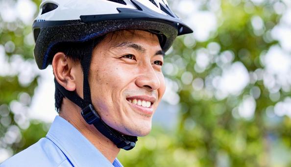 自転車用ヘルメットをかぶる男性 自転車用ヘルメットをかぶる男性の写真