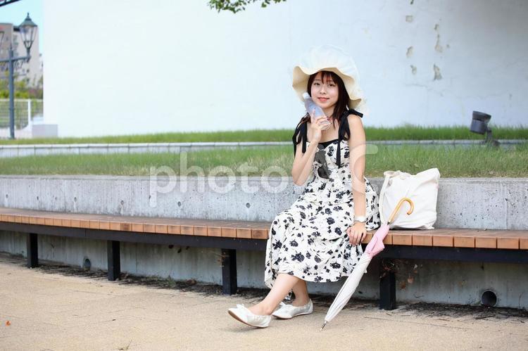 ペットボトルの冷たい水を頬にあてる女性 女性,若い,20代の写真素材