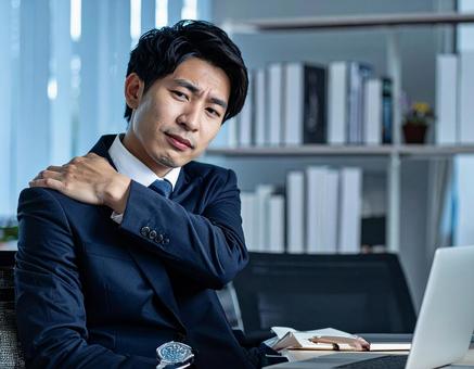 辛い肩凝りで苦しむ男性 辛い肩凝りで苦しむ男性の写真