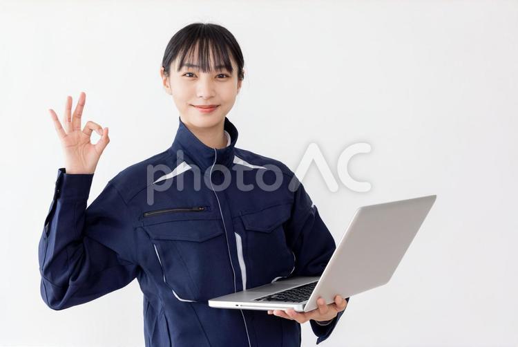 ノートパソコンを使う作業服の女性OK 女性,人物,日本人の写真素材