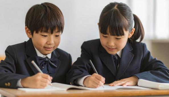学校の教室で勉強している小学生2人の写真
