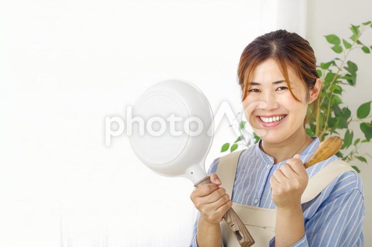 調理器具を持つ元気な女性のイメージ 料理,笑顔,笑うの写真素材