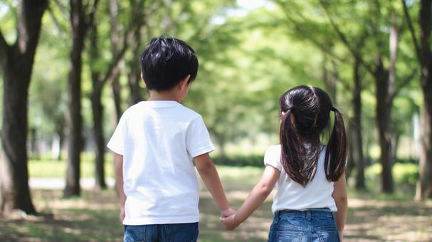 仲良く手をつないで歩くきょうだい 仲良く手をつないで歩くきょうだいの写真
