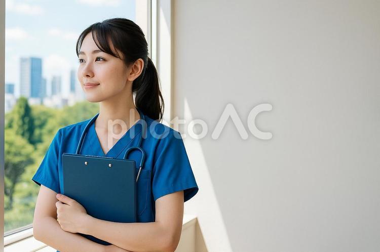 窓辺で笑顔で佇む看護師 女性,看護師,スクラブの写真素材