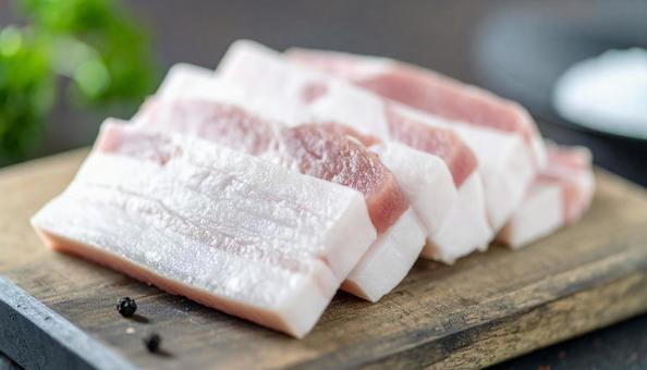 カッティングボードの上の豚バラ肉 カッティングボードの上の豚バラ肉の写真