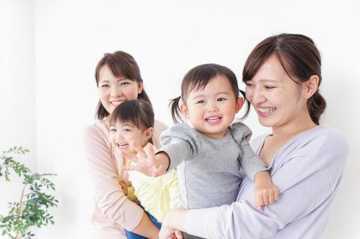 だっこをする2組の親子 だっこをする2組の親子 主婦,女の子,幼稚園児の写真素材