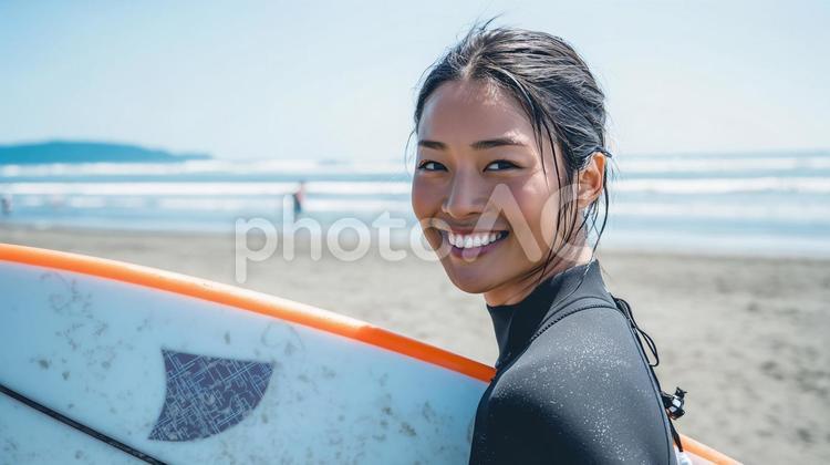 海辺の砂浜でサーフボードを抱え歩く女性 夏,海辺,サーフィンの写真素材