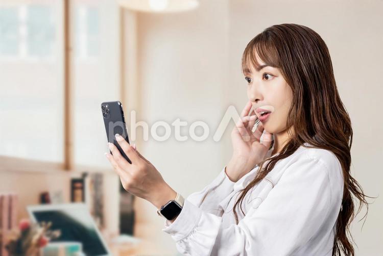 スマホの画面を見て驚くビジネスウーマン 女性,ビジネス,スマホの写真素材