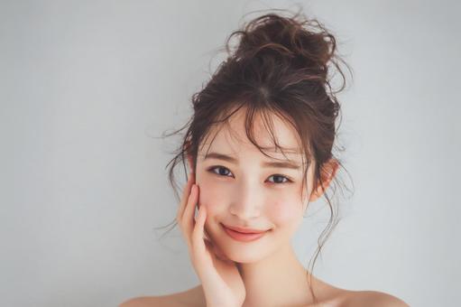 ナチュラルメイクの若い女性が優しく微笑むの写真