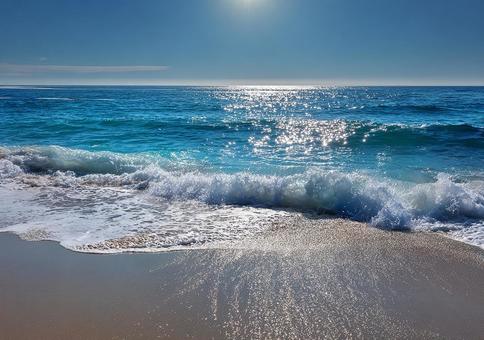 太陽が輝く青い海と砂浜 太陽が輝く青い海と砂浜の写真