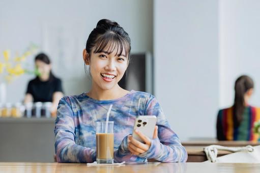 カフェでスマホを見る若い女性 カフェでスマホを見る若い女性 カフェ,スマホ,女性の写真素材