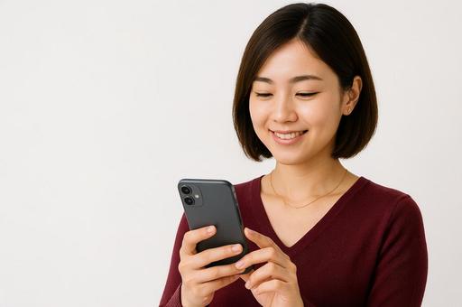 携帯を見て微笑む女性 携帯を見て微笑む女性の写真