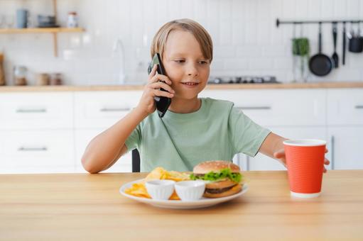 携帯で電話している男の子 携帯で電話している男の子の写真