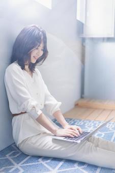 自宅でパソコンを使う若い女性 自宅でパソコンを使う若い女性 デスクワーク,女性,若いの写真素材