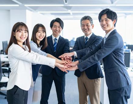 オフィスで円陣を組んでチームワーク醸成 オフィスで円陣を組んでチームワーク醸成の写真