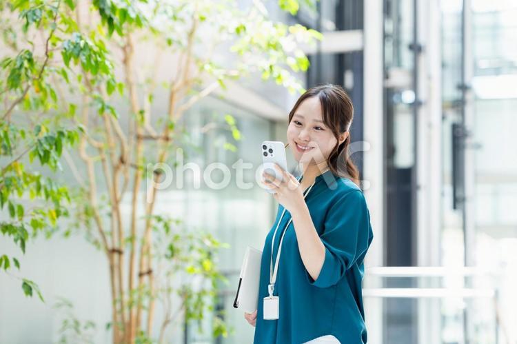 オフィスでスマホを見るビジネスウーマン スマートフォン,エンジニア,ビジネスウーマンの写真素材
