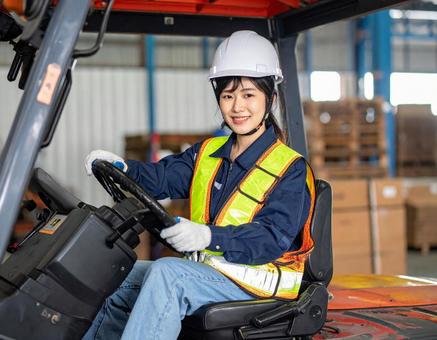 フォークリフトを運転する女性作業員の写真