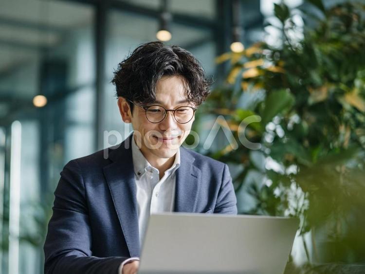おしゃれなスペースでミーティングする男性 ビジネス,男性,オンライン会議の写真素材