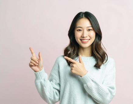 横を指差す女性の写真