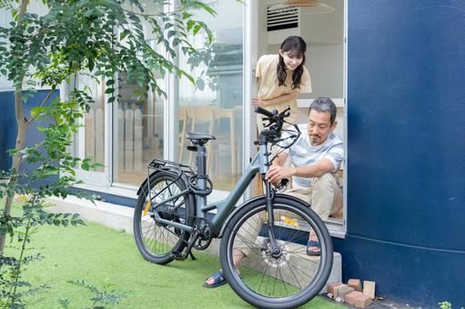 電動自転車をメンテナンスをするミドル男性 電動自転車をメンテナンスをするミドル男性 電動自転車,男性,夫婦の写真素材