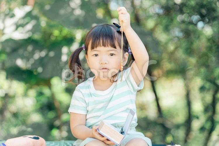 おもちゃのネックレスで遊ぶ日本人の女の子 子供,ネックレス,アクセサリーの写真素材