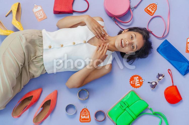 セールのタグとファッション小物と寝転ぶアジア人女性 セール,ショップ,女性の写真素材