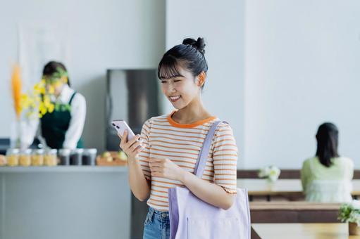 カフェで来店する若い女性 カフェで来店する若い女性 カフェ,スマホ,女性の写真素材