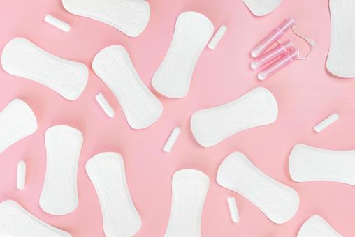 ピンク背景にたくさんのタンポンと生理用ナプキンが置かれている 生理,月経,生理用品の写真素材