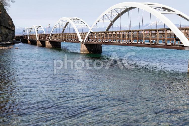 雪が残る山と木製の白い遊歩道 道南,江差,かもめの遊歩道の写真素材