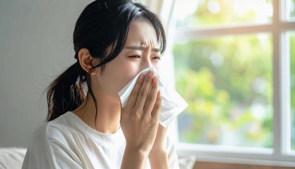 ティッシュで鼻をかむ日本人の若い女性 ティッシュで鼻をかむ日本人の若い女性の写真