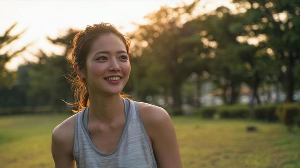 夕暮れにジョギングをする女性 夕暮れにジョギングをする女性の写真