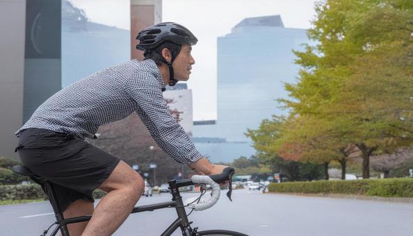 ロードバイクでサイクリングする男性 ロードバイクでサイクリングする男性の写真