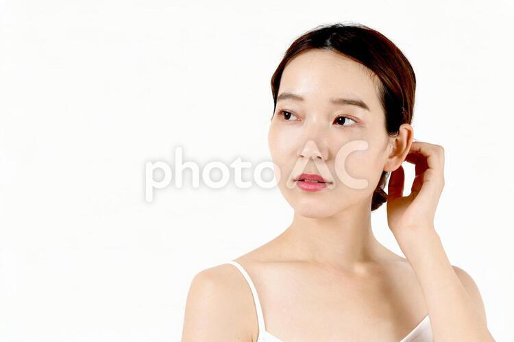 スキンケアをする女性のイメージ 女性,顔,白バックの写真素材
