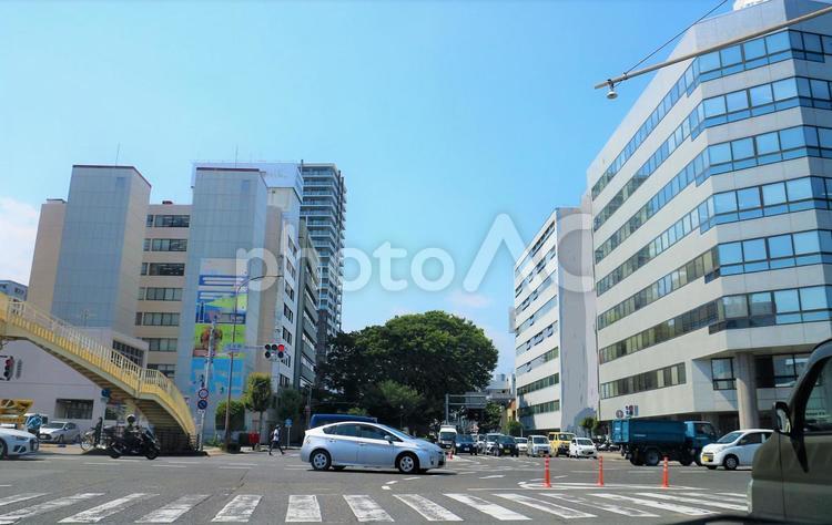 交差点の中で待つ車 交差点,歩道橋,オフィスビルの写真素材