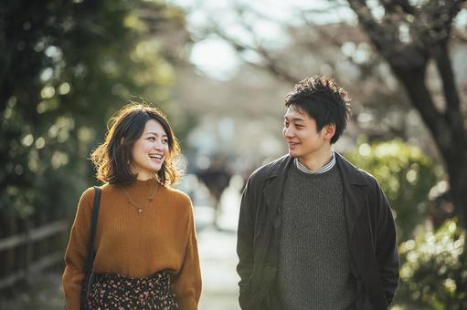 並んで道を歩く笑顔のカップル 並んで道を歩く笑顔のカップルの写真