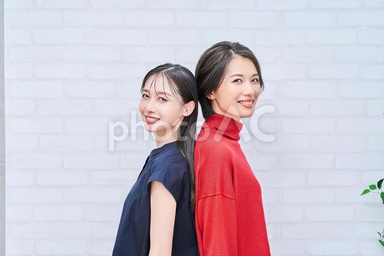 背中合わせで立つ2人の女性たち 背中合わせ,女性,2人の写真素材