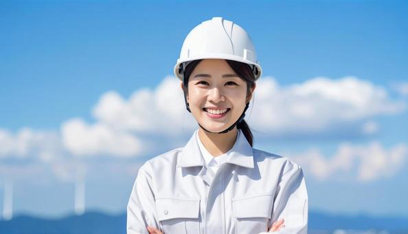 青空の下で笑顔の作業服を着た若い女性 青空の下で笑顔の作業服を着た若い女性の写真