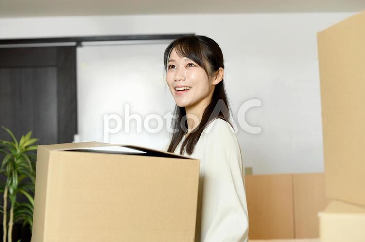 段ボールを運ぶ笑顔のアジア人の女性 女性,引っ越し,段ボールの写真素材
