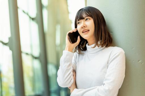 スマホで通話をする若い女性 女性,人物,秋の写真素材