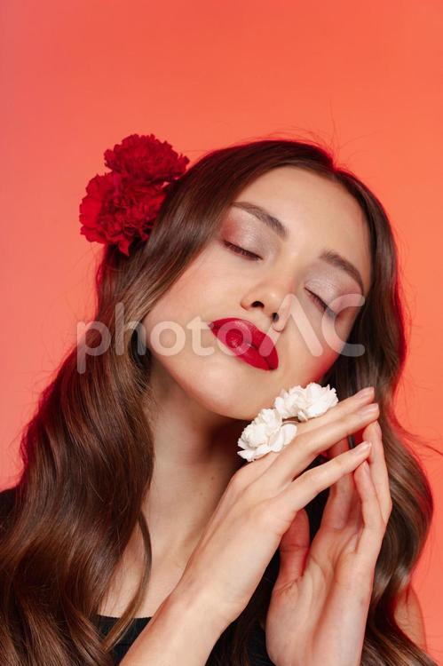 目を瞑る髪と指に花をつけた女性 女性,目を瞑る,ポーズの写真素材