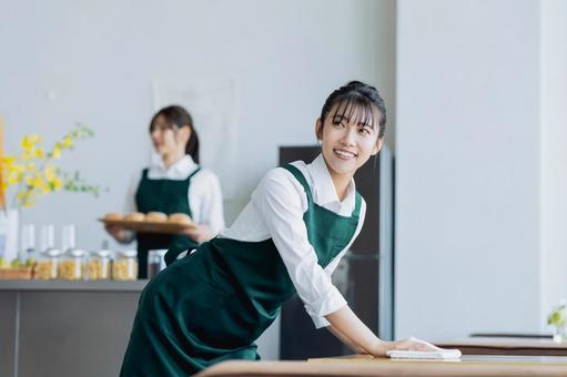 カフェで働く若い女性 カフェで働く若い女性の写真