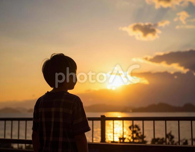 夕焼けの空を見つめる日本人の少年 ビジョン,将来,子供の写真素材