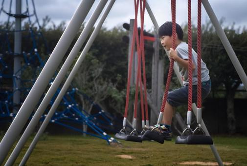 ＜素材＞秋の公園でブランコで遊ぶ男の子 子供,笑顔,ブランコの写真素材
