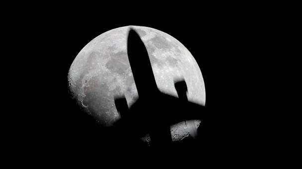 月を横切る飛行機のシルエット 月を横切る飛行機のシルエットの写真