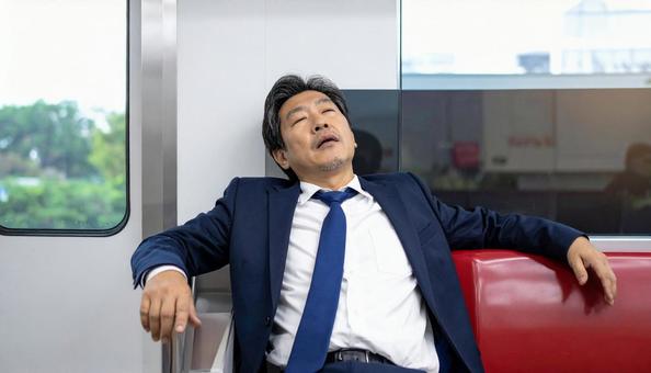 電車内で寝る中年男性 電車内で寝る中年男性の写真