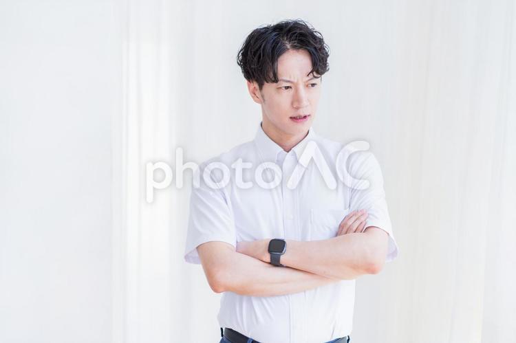 腕組みしているビジネスマン 男性,ビジネスマン,悩むの写真素材