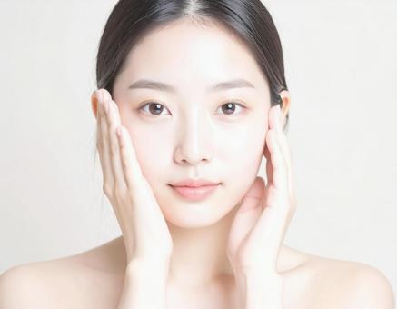 フェイスマッサージをする女性 フェイスマッサージをする女性の写真