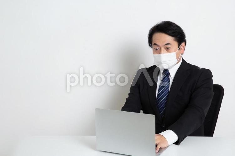 トラブルに気付いたマスクをしている中年のサラリーマン男性（コピースペース） 中年,上司,会社員の写真素材