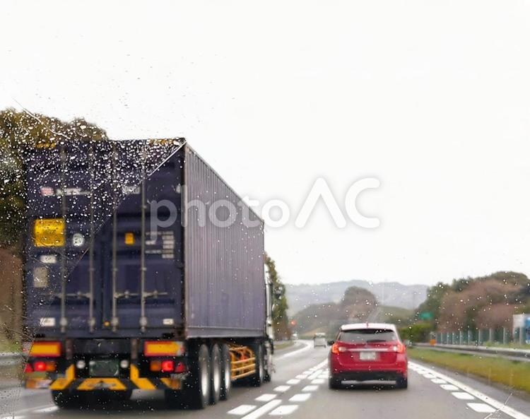 コンテナ輸送車　雨の高速を走る トラック,追い越し,コンテナの写真素材